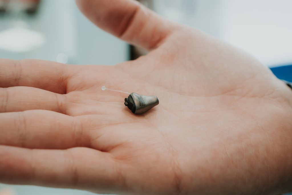 Personal de Audite sosteniendo un audífono